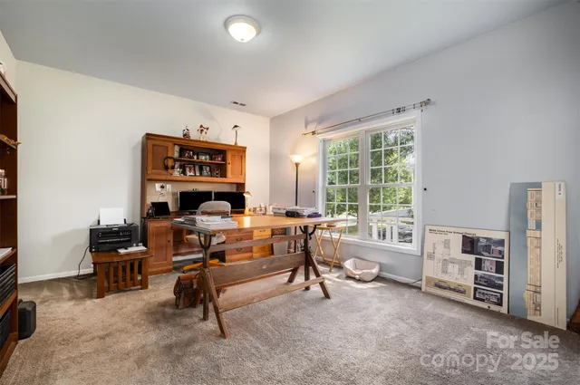a view of a workspace with furniture and a window