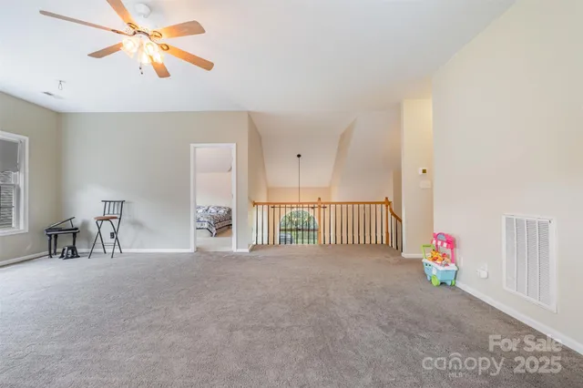 a view of a room with a ceiling fan and window