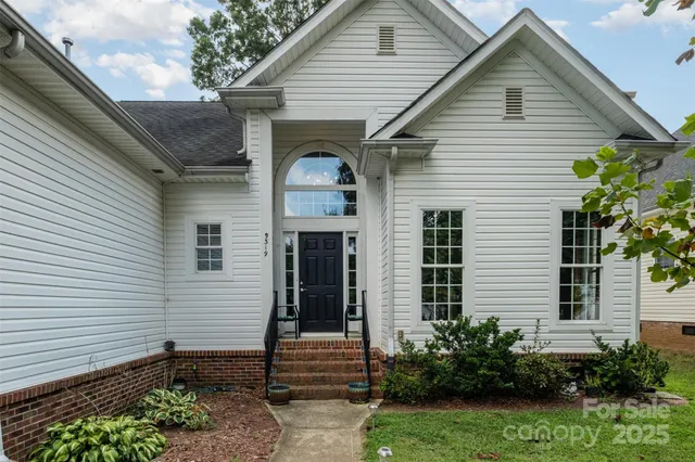 a view of a white house next to a yard