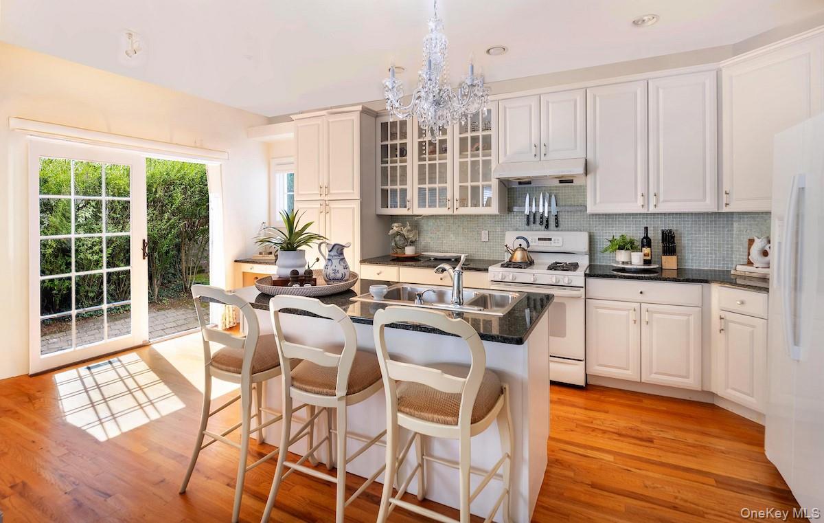 66 Landing Drive Dobbs Ferry, NY 10522 - Photo 12 of 44 a kitchen with stainless steel appliances granite countertop a stove top oven a sink dishwasher and white cabinets with wooden floor
