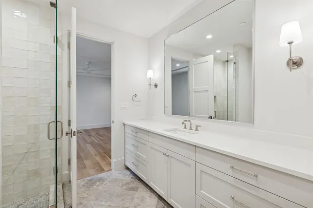 a spacious bathroom with a shower sink and mirror