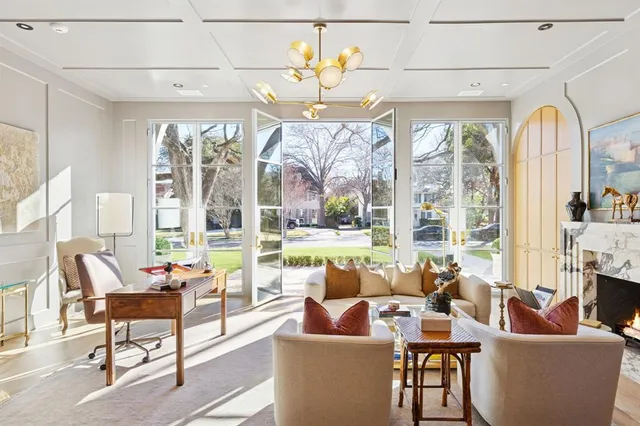 a living room with fireplace furniture and a large window
