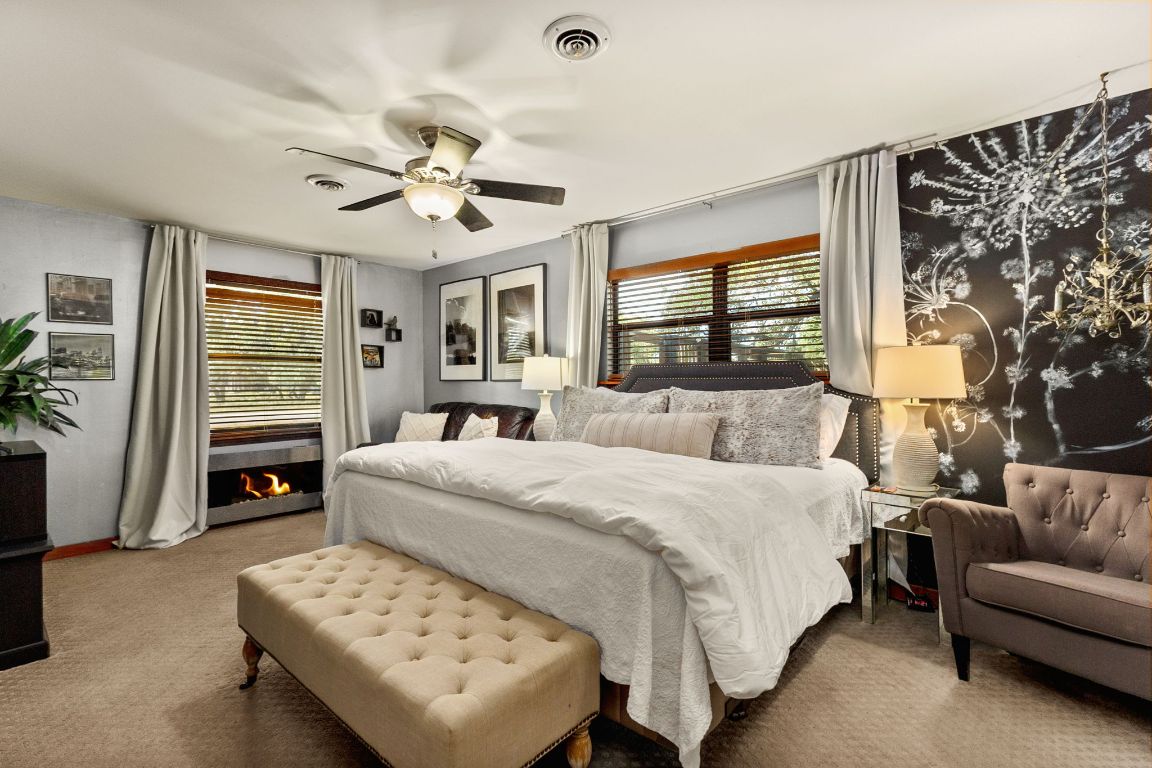 303 Lange Road Wimberley, TX 78676 - Photo 21 of 31 a bedroom with a bed couches and a flat tv screen