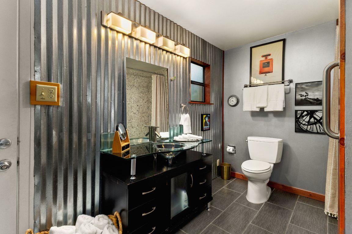 303 Lange Road Wimberley, TX 78676 - Photo 23 of 31 a bathroom with a toilet sink and mirror