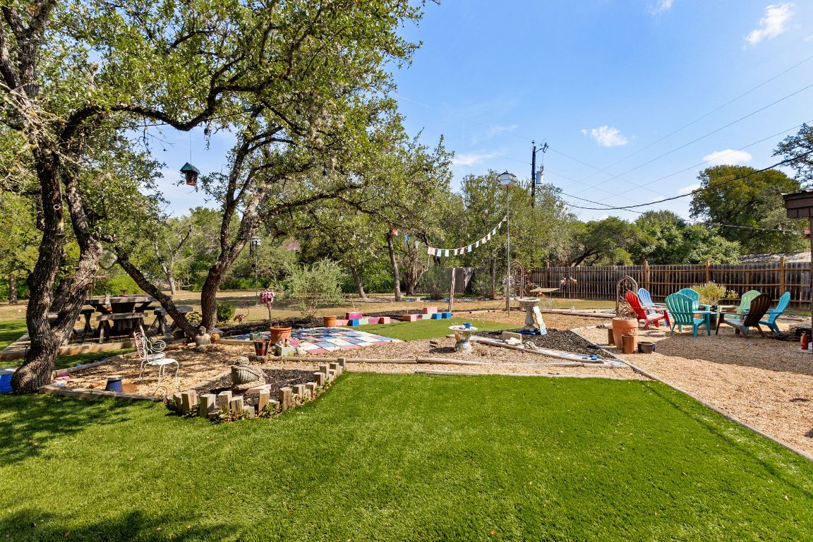 303 Lange Road Wimberley, TX 78676 - Photo 26 of 31 a view of a lake with lawn chairs and a fire pit