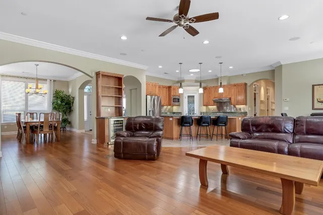 a kitchen with stainless steel appliances kitchen island granite countertop a stove a refrigerator a oven a sink with a dining table and chairs