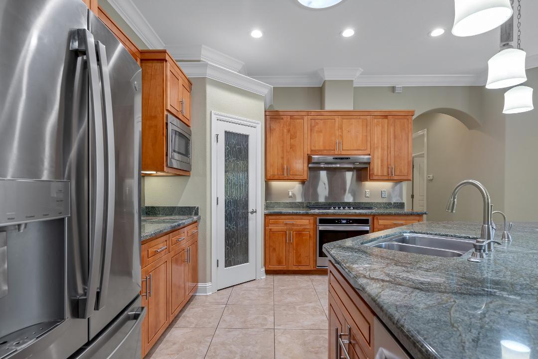 3685 Wimbledon Drive Redding, CA 96002 - Photo 21 of 70 a kitchen with stainless steel appliances granite countertop a sink stove and refrigerator