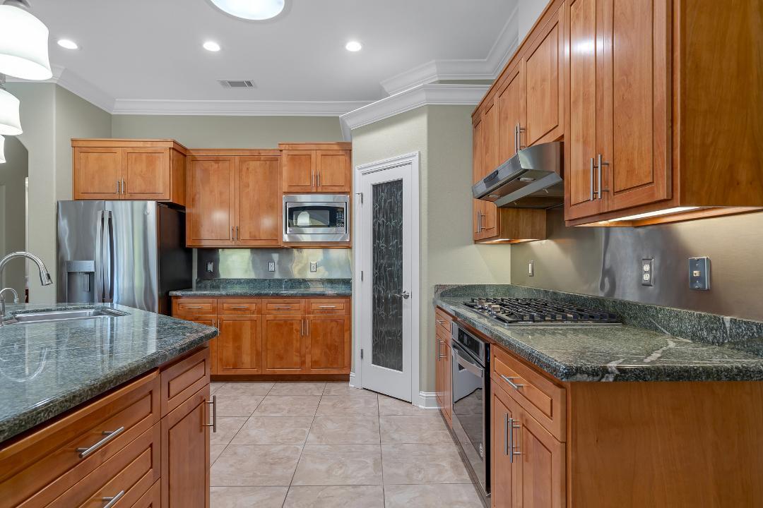 3685 Wimbledon Drive Redding, CA 96002 - Photo 26 of 70 a kitchen with stainless steel appliances granite countertop a sink a stove and a refrigerator