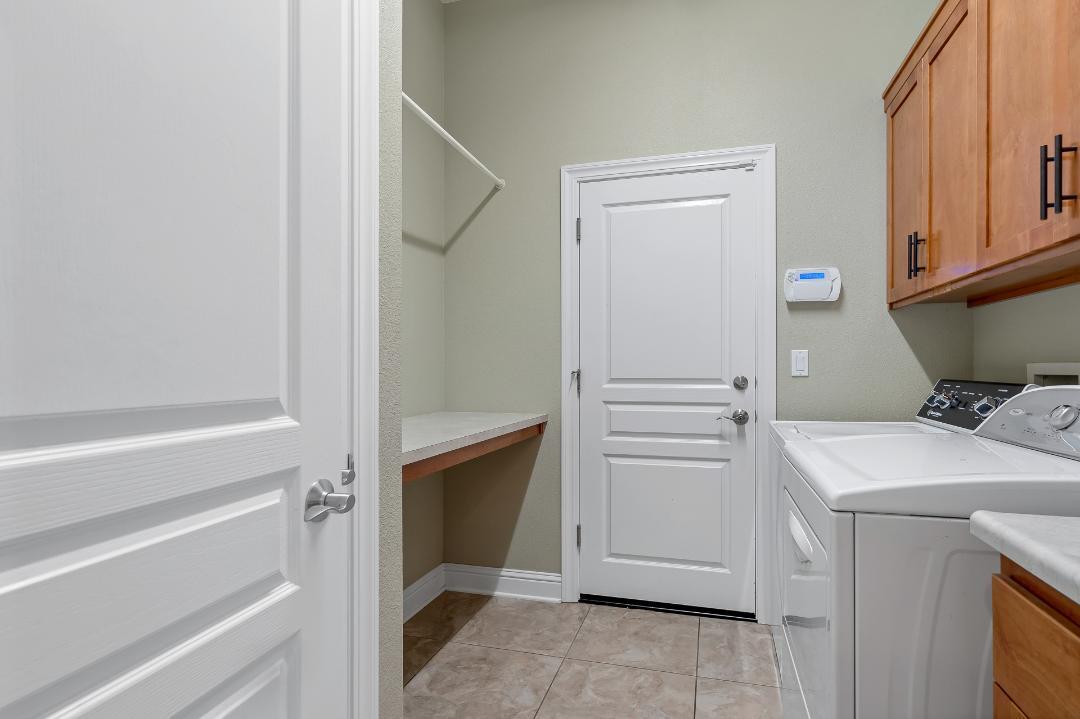 3685 Wimbledon Drive Redding, CA 96002 - Photo 31 of 70 a view of washer and dryer with kitchen in the background