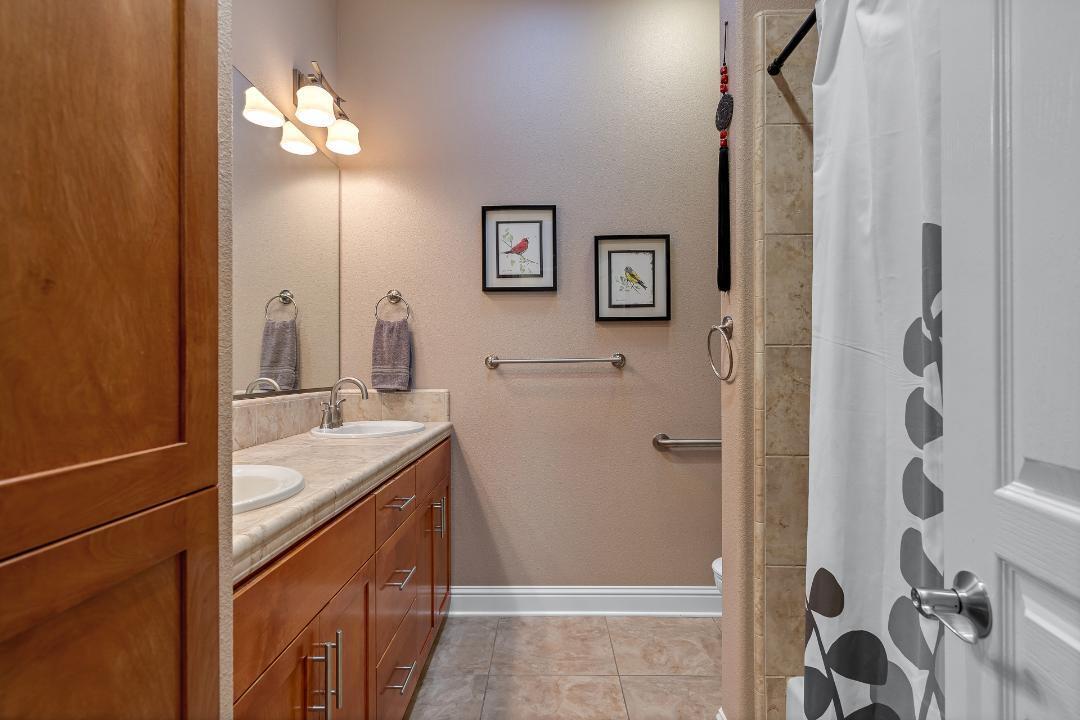 3685 Wimbledon Drive Redding, CA 96002 - Photo 36 of 70 a bathroom with a granite countertop sink a mirror and shower