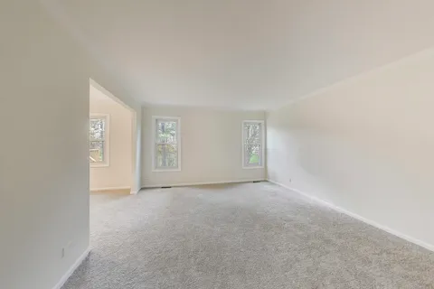 a view of an empty room with closet and a window