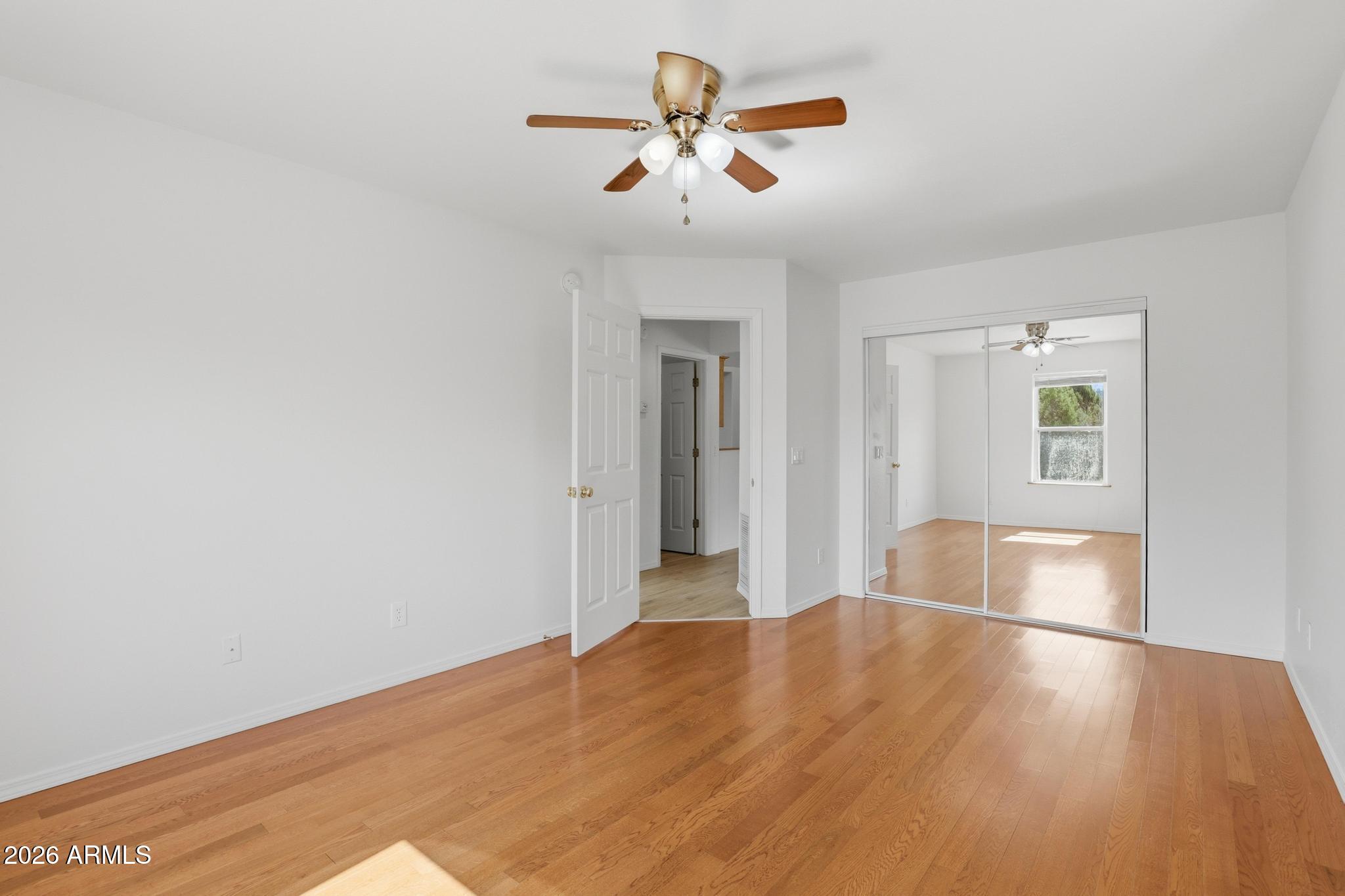 8780 Singletree Lane Payson, AZ 85541 - Photo 20 of 37 a view of an empty room with window and wooden floor