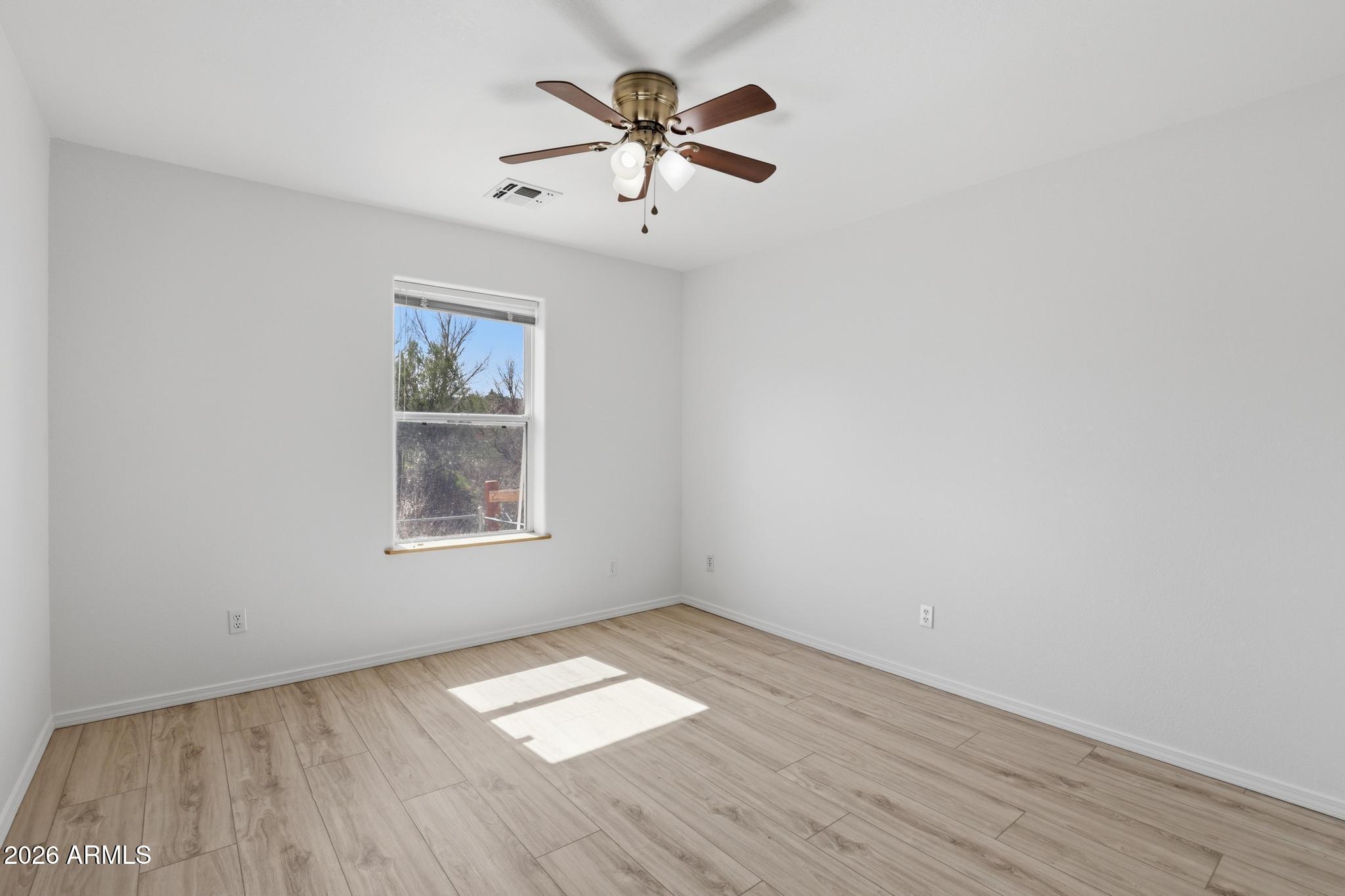 8780 Singletree Lane Payson, AZ 85541 - Photo 21 of 37 an empty room with wooden floor and windows