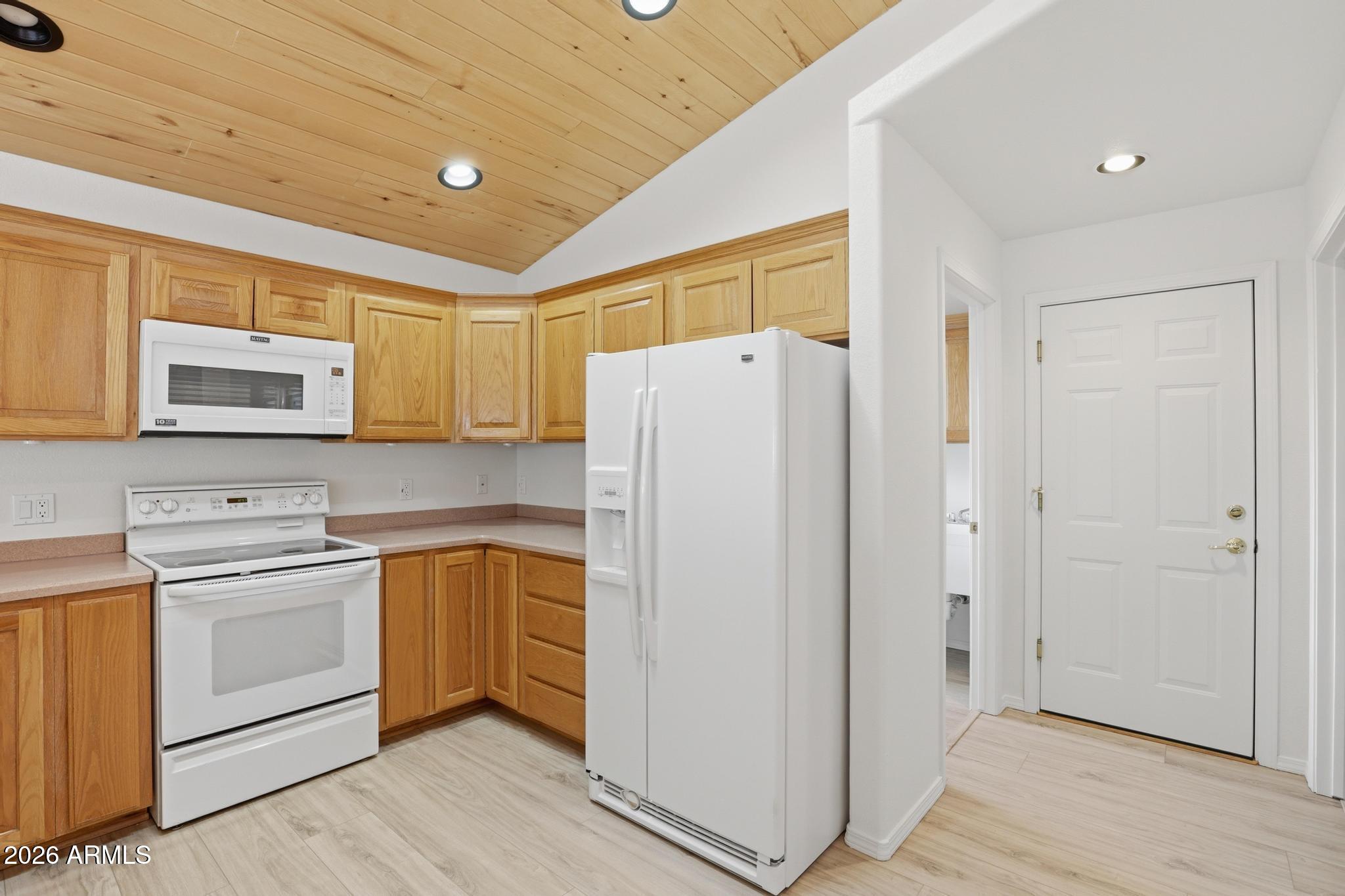 8780 Singletree Lane Payson, AZ 85541 - Photo 9 of 37 a kitchen with a refrigerator a stove a microwave and cabinets
