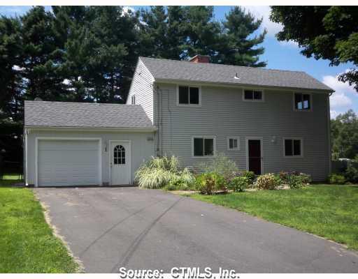 1 Hartland Road Simsbury, CT 06081 - Photo 1 of 1 a front view of a house with a garden and plants