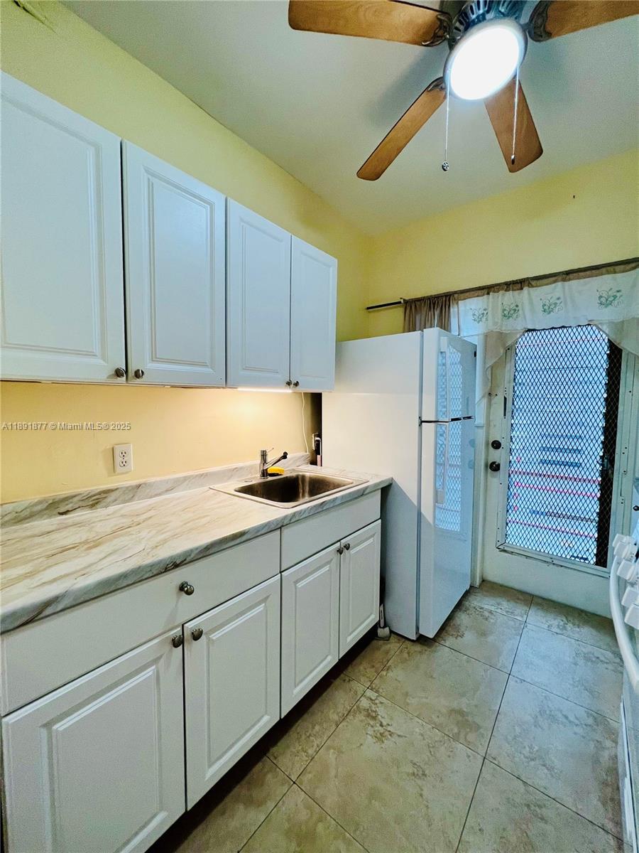 1141 Meridian Avenue, Unit 6 Miami Beach, FL 33139 - Photo 8 of 11 a kitchen with cabinets and a refrigerator