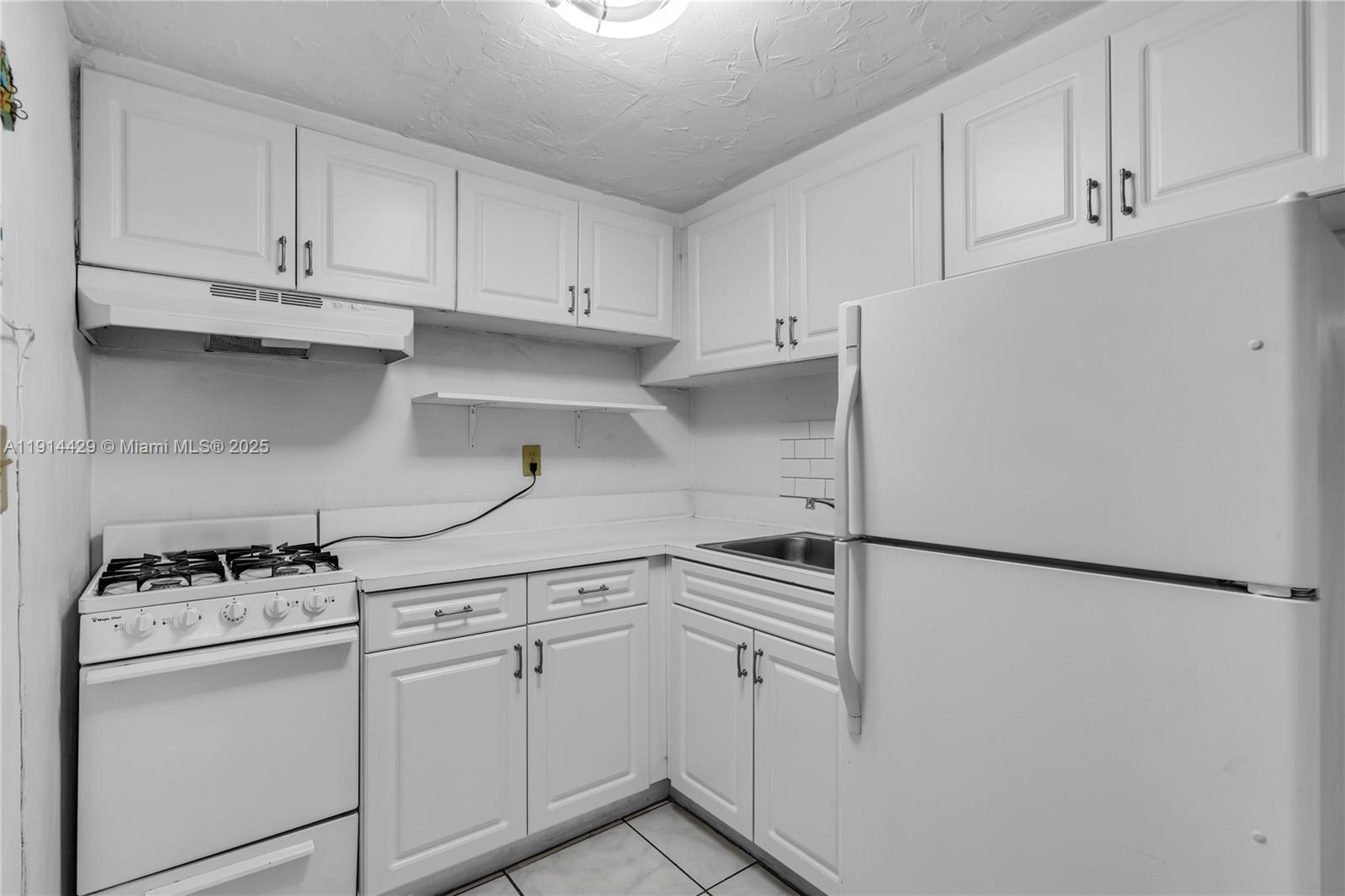 1330 West 54th Street, Unit 302C Hialeah, FL 33012 - Photo 7 of 20 a kitchen with white cabinets and white appliances