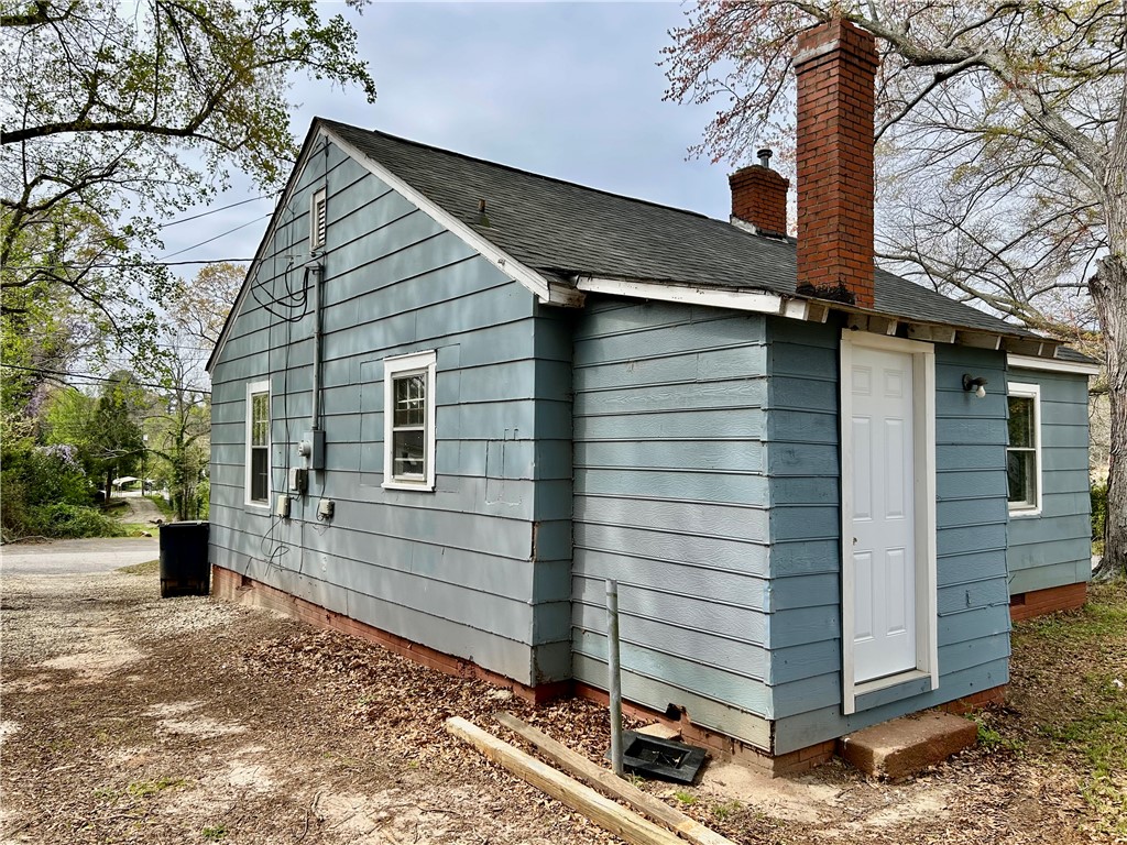 181 Sumter Street Anderson, SC 29621 - Photo 15 of 17 This charming home features classic siding and brick chimneys, creating a cozy and inviting exterior.