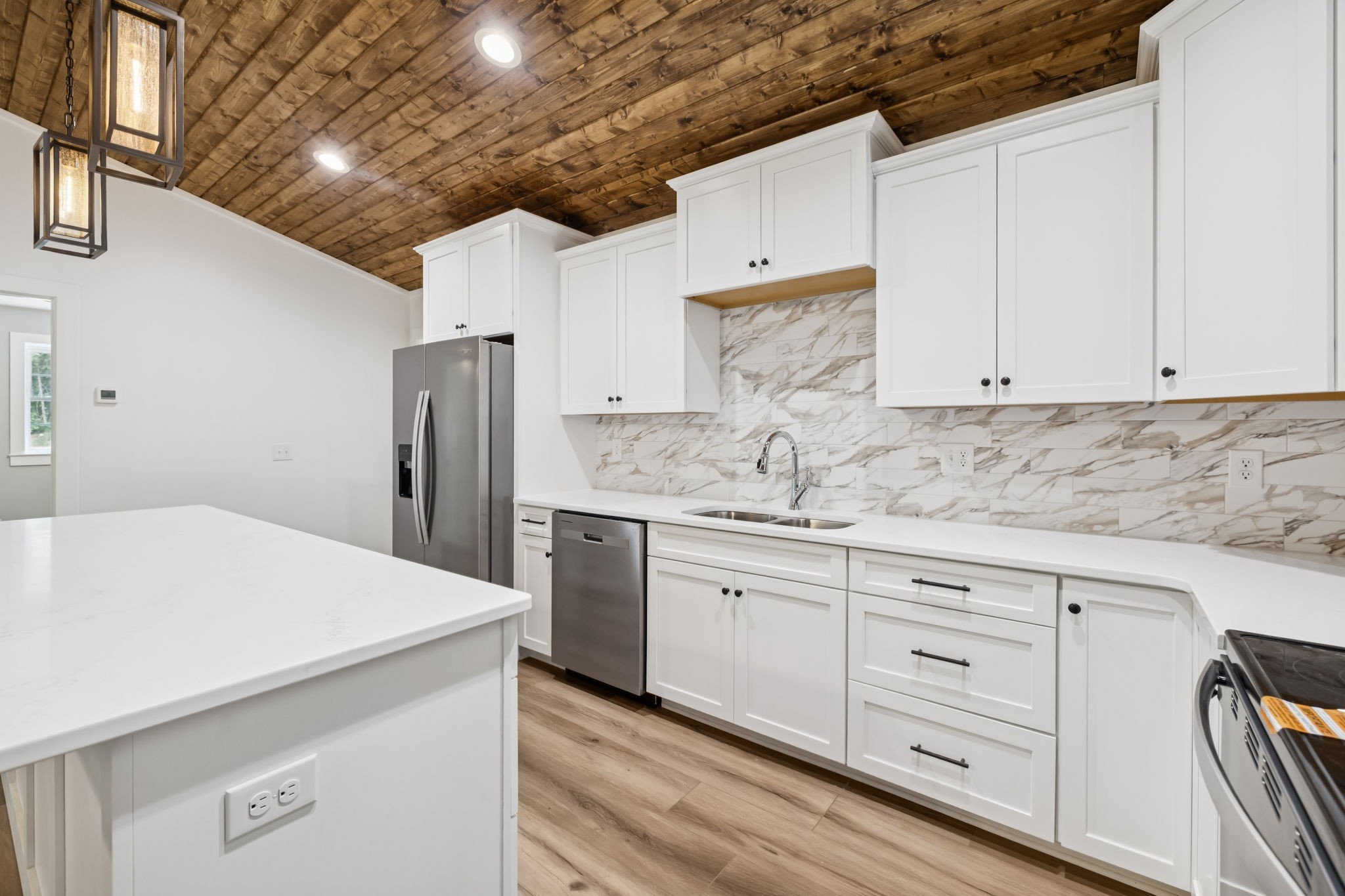 a kitchen with granite countertop white cabinets and refrigerator