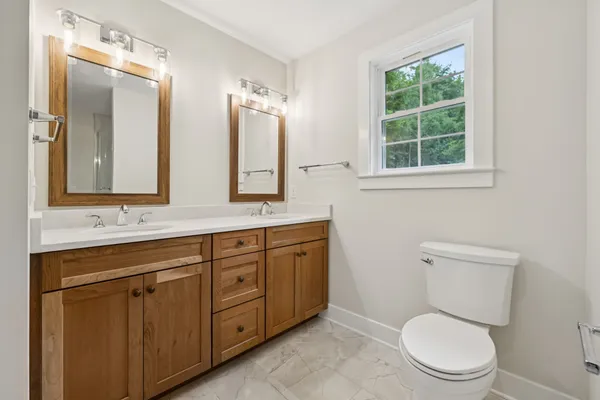 a bathroom with a toilet a sink and a mirror