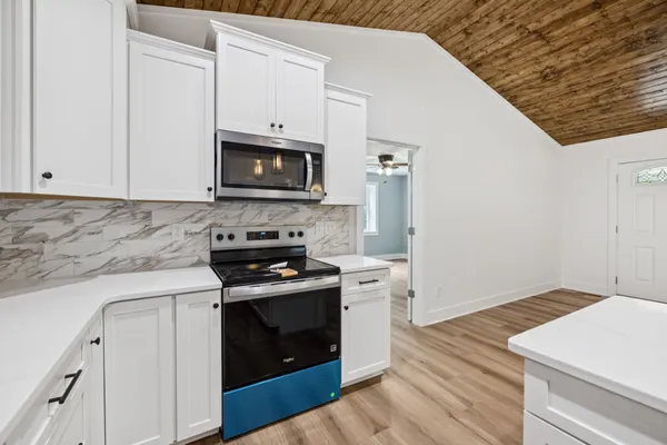 a kitchen with granite countertop cabinets stainless steel appliances and wooden floor