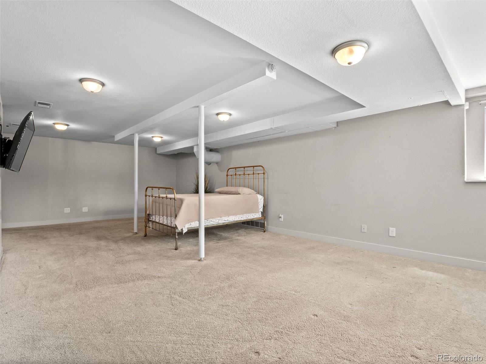 6595 West 46th Place Wheat Ridge, CO 80033 - Photo 31 of 48 a white bed sitting in a room next to a lamp