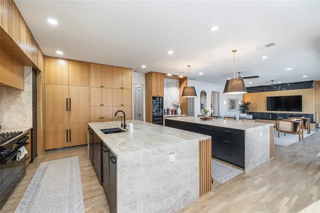 a kitchen with stainless steel appliances granite countertop a sink a stove and a refrigerator