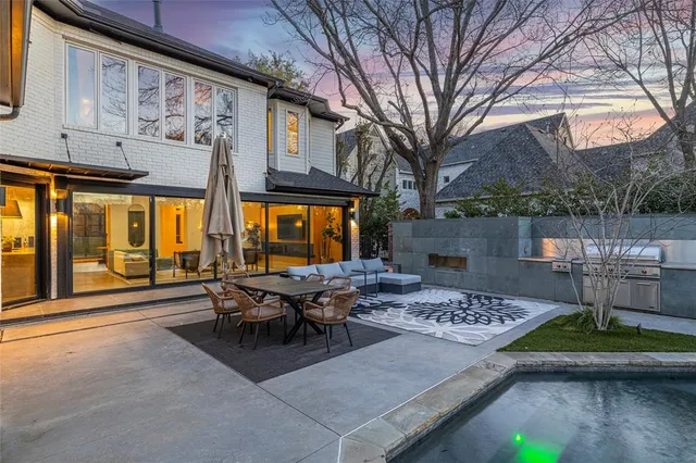 a roof deck with table and chairs and potted plants