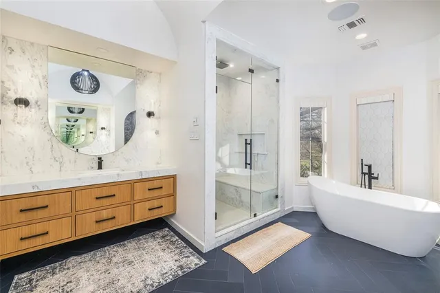 a bathroom with a tub sink and mirror
