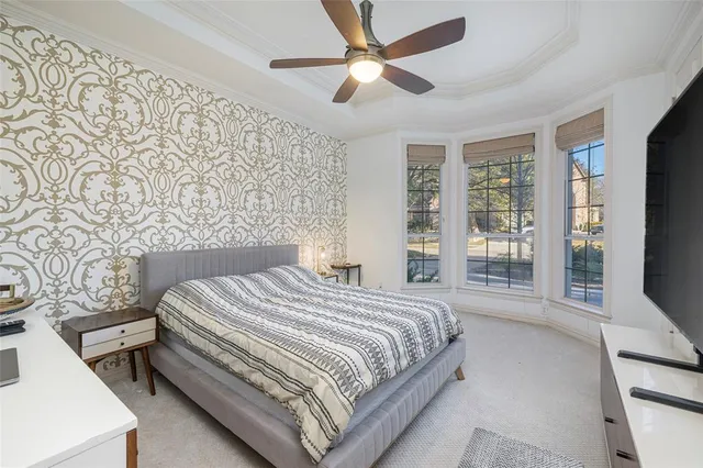 a bedroom with a bed tv and a window