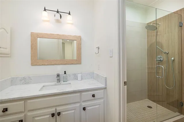a bathroom with a shower sink and mirror