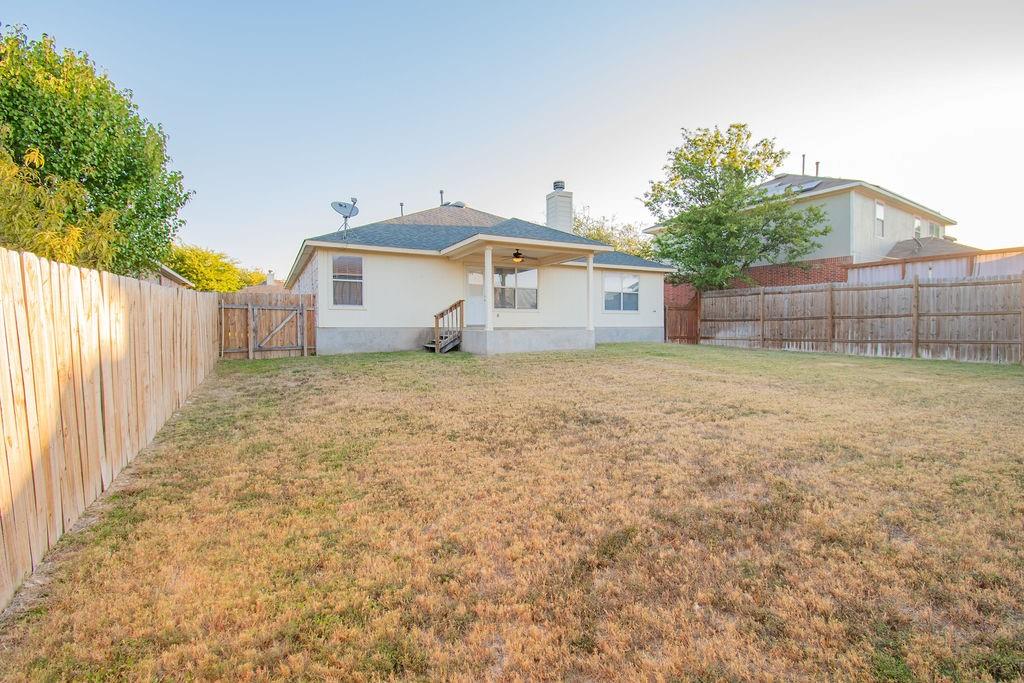 312 Pheasant Ridge Drive Round Rock, TX 78665 - Photo 32 of 34 A fully fenced backyard with a covered patio, perfect for outdoor enjoyment.