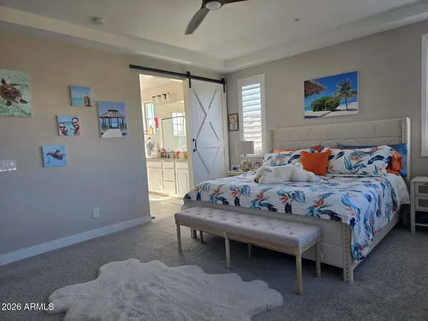 a bedroom with a bed and a lamp on dresser