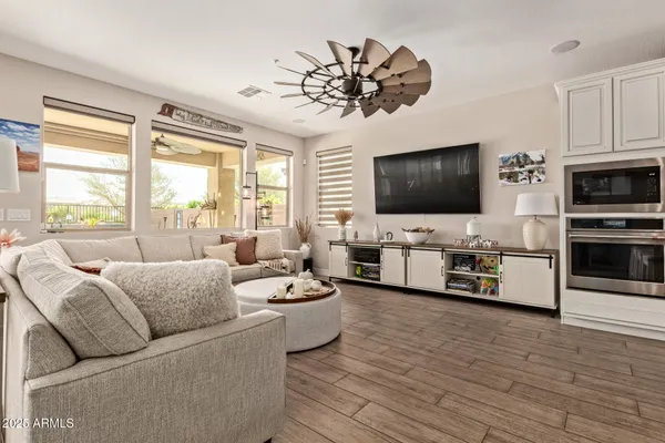 a living room with stainless steel appliances kitchen island granite countertop furniture a rug kitchen view and a chandelier
