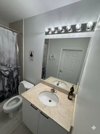 a bathroom with a sink toilet and mirror
