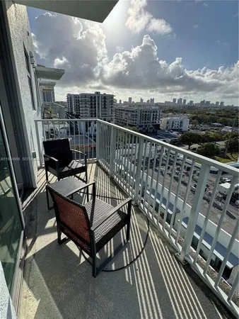 a view of a balcony with two chairs and wooden floor
