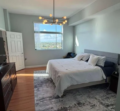 a bedroom with a bed and a chandelier