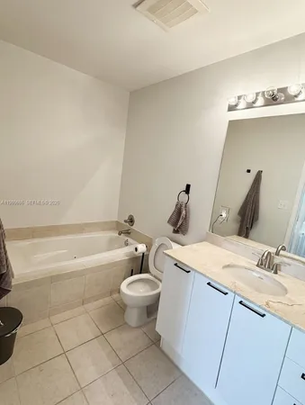 a bathroom with a granite countertop sink a toilet and bathtub