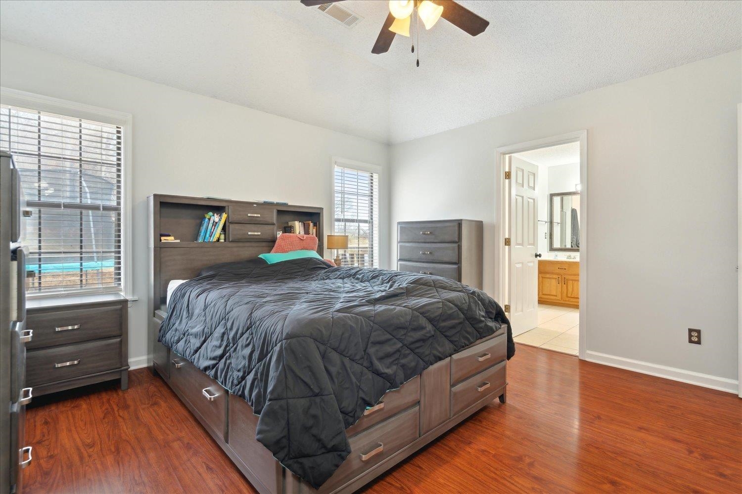 88 East Rae Road Munford, TN 38058 - Photo 19 of 30 Bedroom featuring ceiling fan, vaulted ceiling, dark wood-type flooring, and ensuite bath