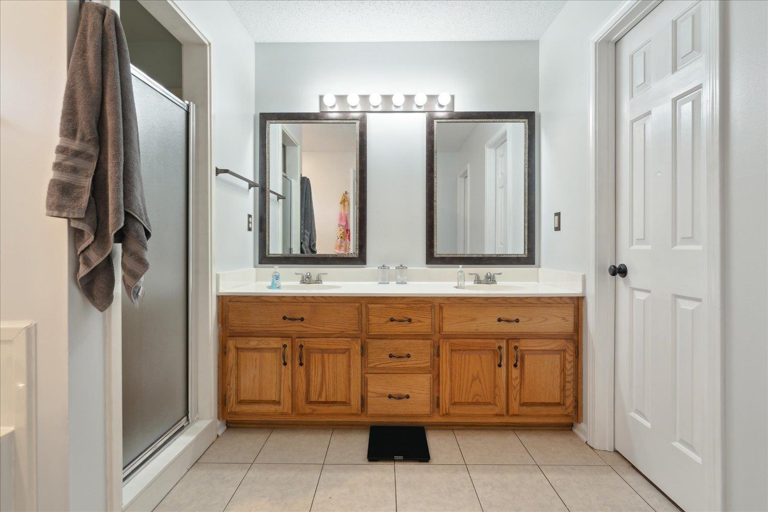 88 East Rae Road Munford, TN 38058 - Photo 20 of 30 Bathroom featuring vanity, a shower with shower door, tile patterned flooring, and a textured ceiling