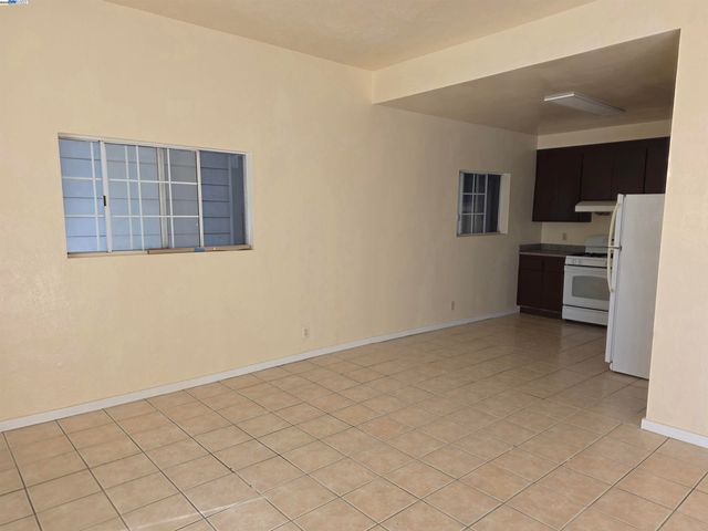 a view of an empty room with a kitchen