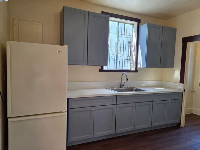 a kitchen with a sink a refrigerator and cabinets
