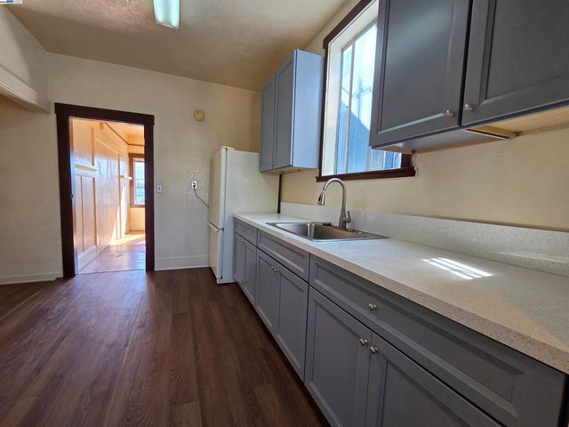 a kitchen with a sink a refrigerator and cabinets