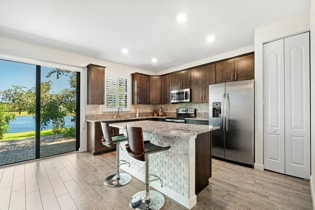 a kitchen with kitchen island a large counter top space appliances and cabinets