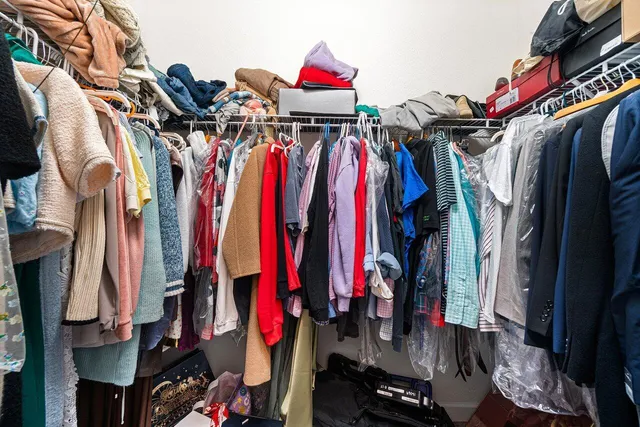 a view of walk in closet with clothes