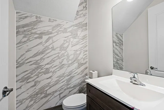 a bathroom with a sink a toilet a mirror and shower curtain