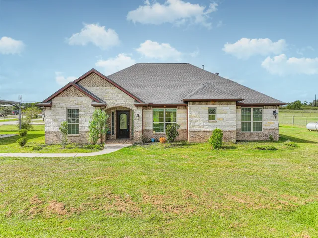 a view of a house with a yard and sitting area