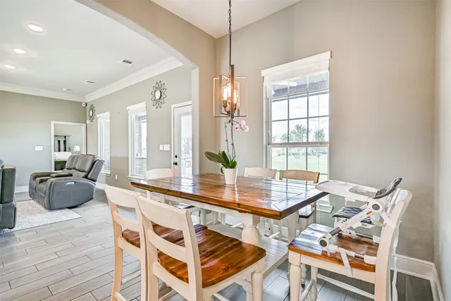 a bedroom with a bed a chandelier and a dresser