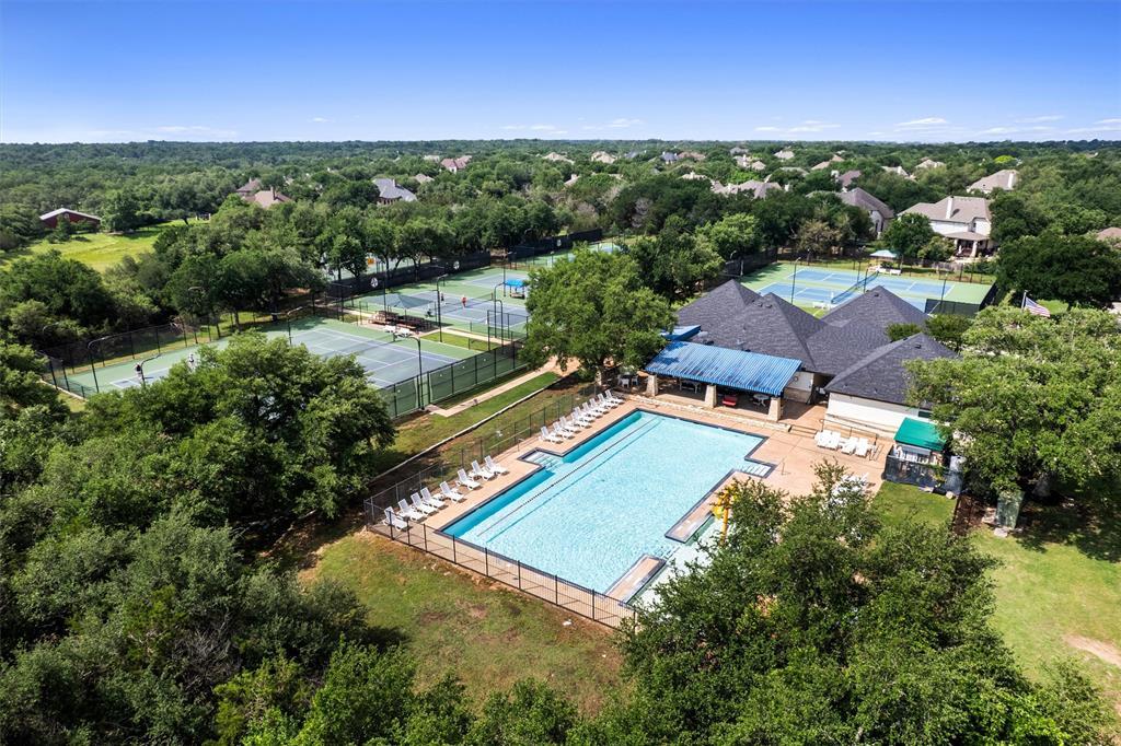 30107 Hamlet Circle Georgetown, TX 78628 - Photo 38 of 40 An aerial perspective showcases a vibrant community recreation area with a sparkling pool and multiple tennis courts amidst lush greenery.