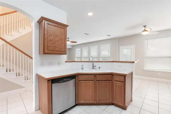 a kitchen with stainless steel appliances a refrigerator a sink a stove and white cabinets
